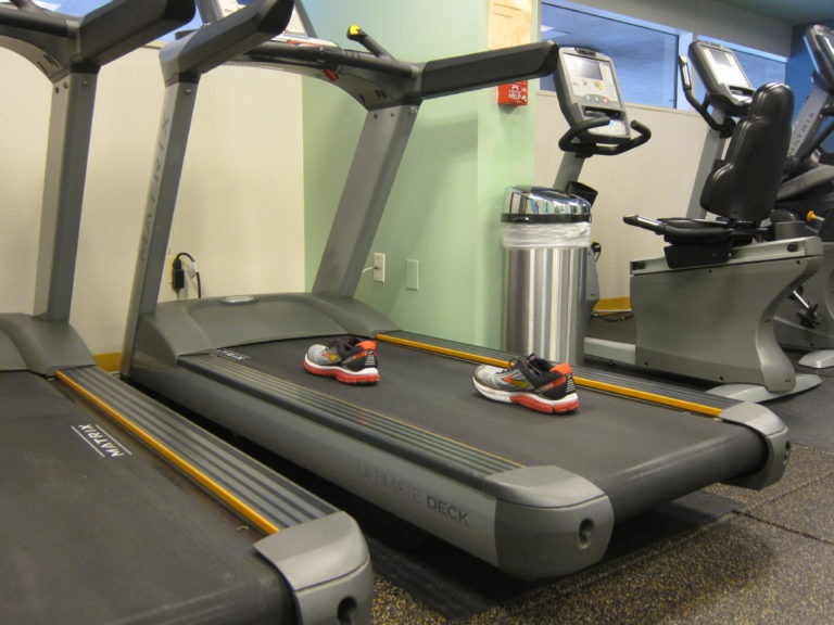 two red black and yellow running shoes on a treadmill